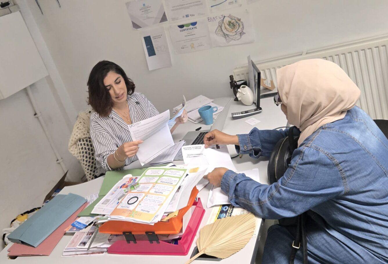 An adviser helping a visitor with paperwork